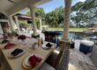 Covered patio hibachi at home setup with dining table and grill ready for a backyard rain backup plan