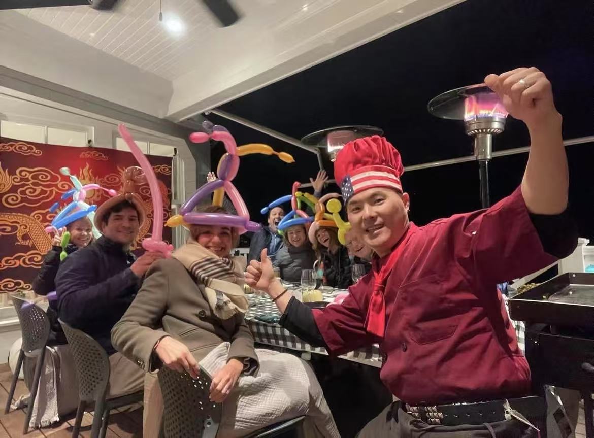 Private hibachi chef and guests celebrating around a portable grill at a US backyard dinner