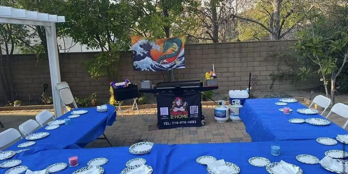 Hibachi 2 Home branded portable grill set up beside guest tables for a private backyard hibachi dinner at home